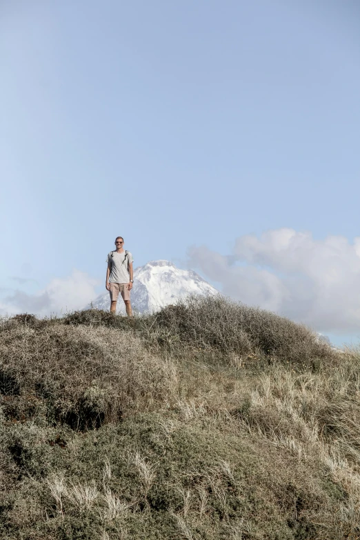 man on a grass covered hill looking down at soing