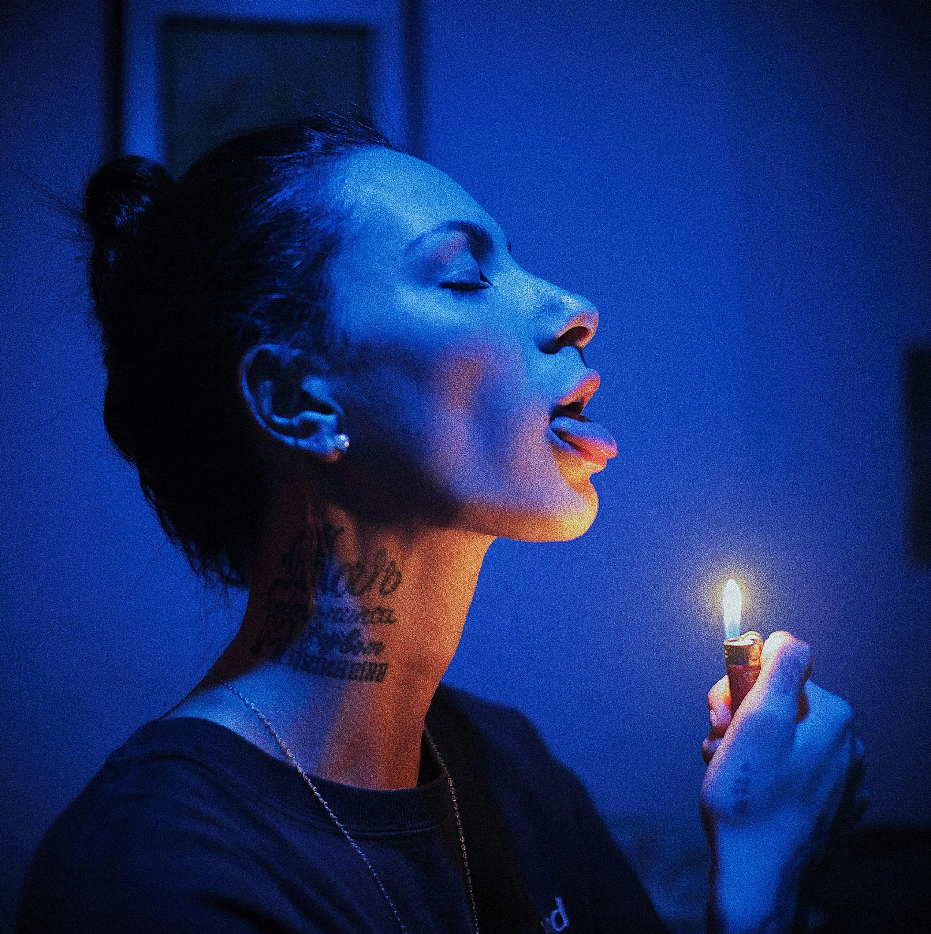 a woman smoking a lighter while wearing dark clothes