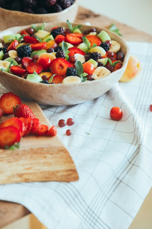 fruits and vegetables are in wooden bowls on the table