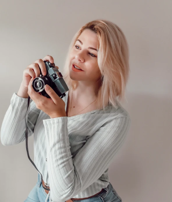 a woman holding a camera taking a po with her hands