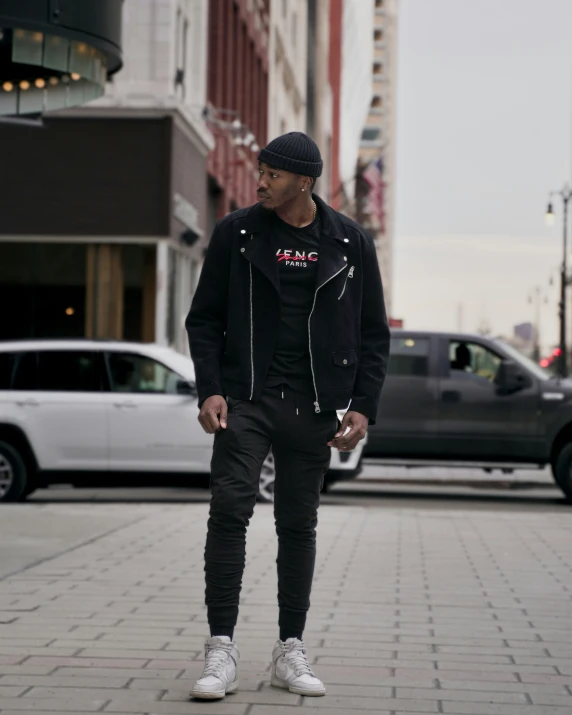 young man standing in the street looking at his cell phone