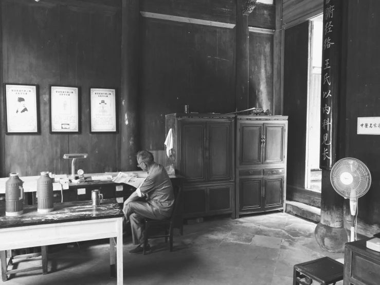 an old po of a woman sitting in a chair at a desk