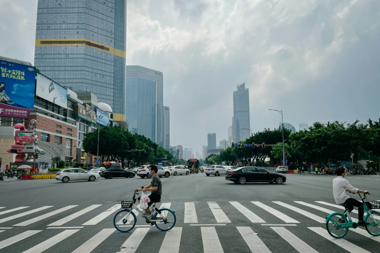 people are riding their bikes across a city intersection