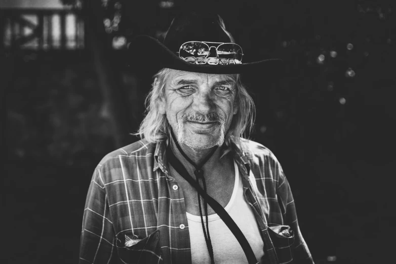 man wearing a hat standing with a camera