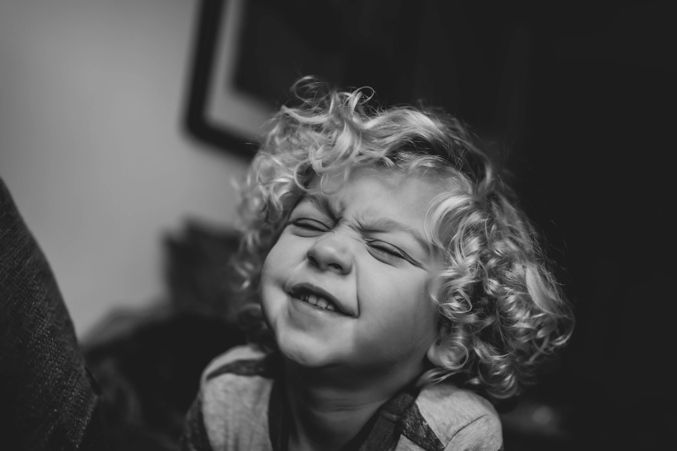 small child with blond hair laughing and looking up