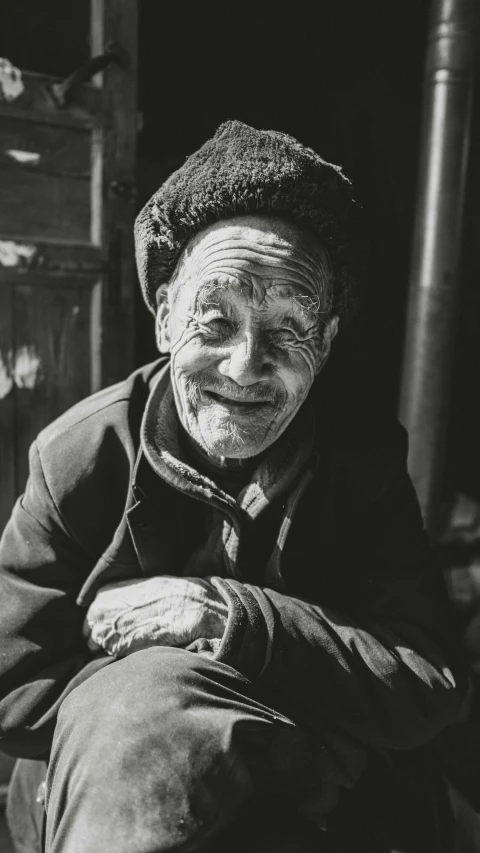 an elderly person wearing an old hat and sitting