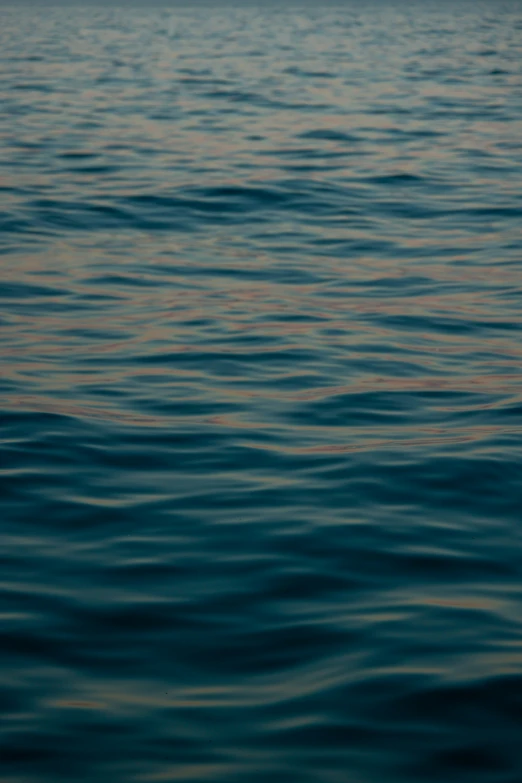 blue ocean waves with a sunset in the distance