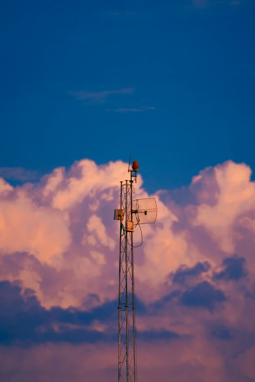 a lone microwave tower stands out against a purple cloud