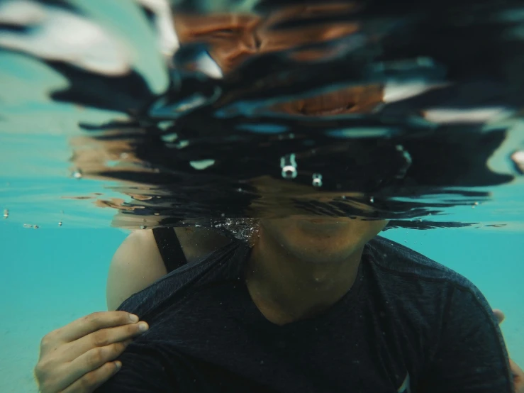 the person is submerged under water and taking pictures