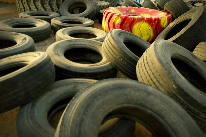 a lot of tires sitting in a pile with a colorful box on top of them