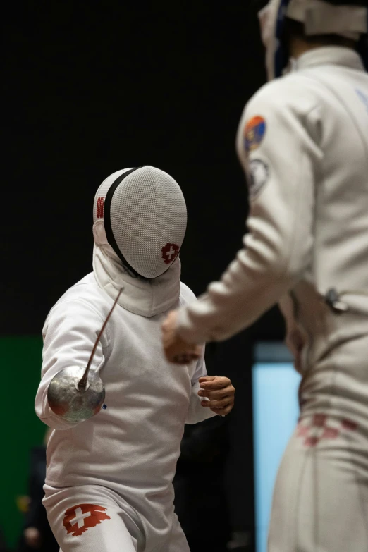 two men in fencing uniforms are fighting each other