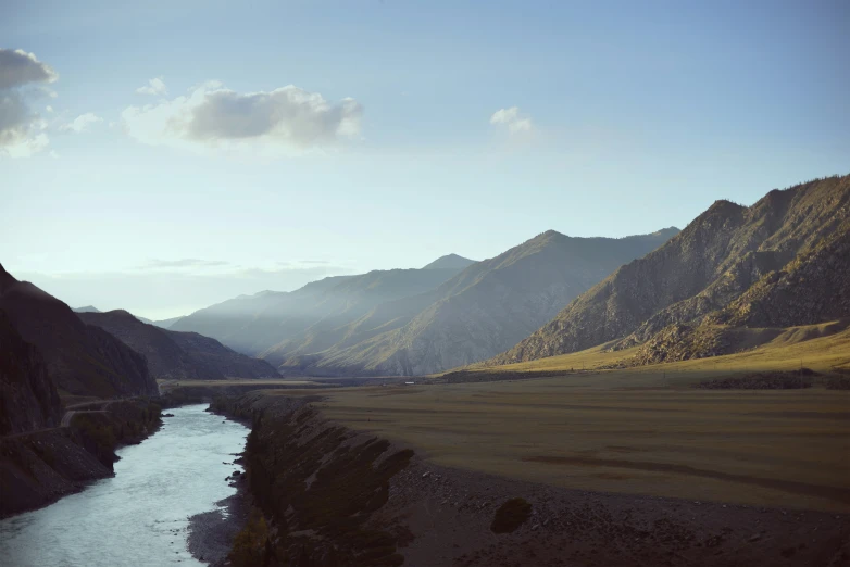 a river is flowing through the landscape in front of some mountains