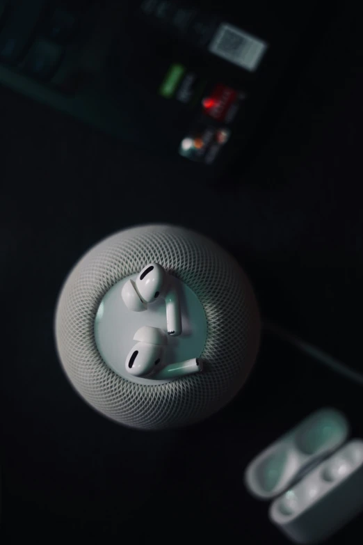 three white headphones, two remote controls and a controller