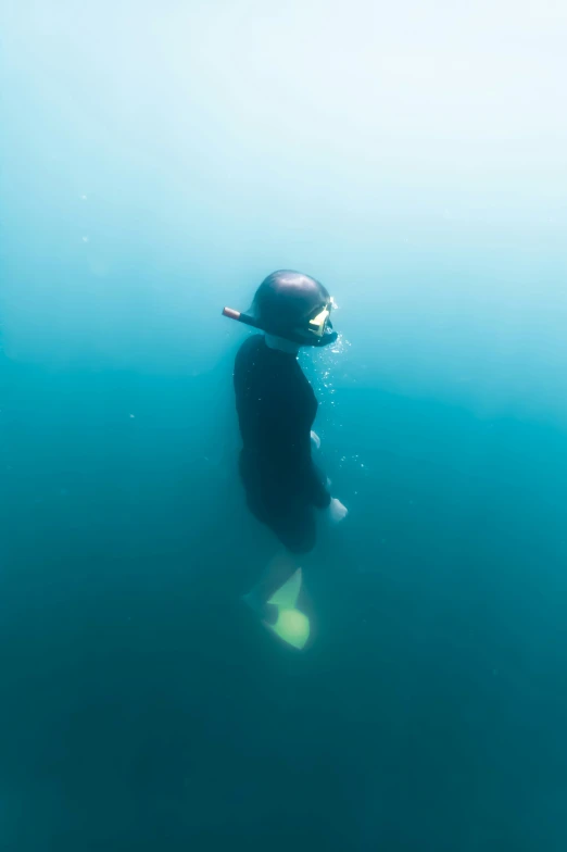 man in a diving mask floating under the water