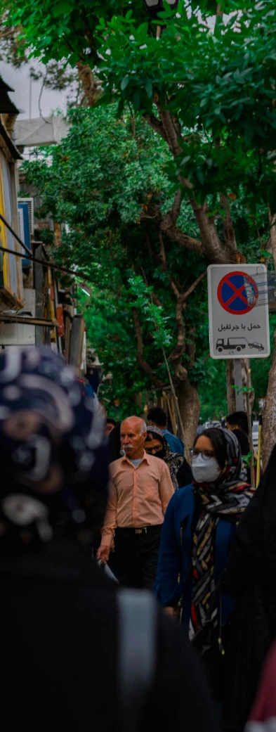 the people are walking around wearing their faces covered with masks