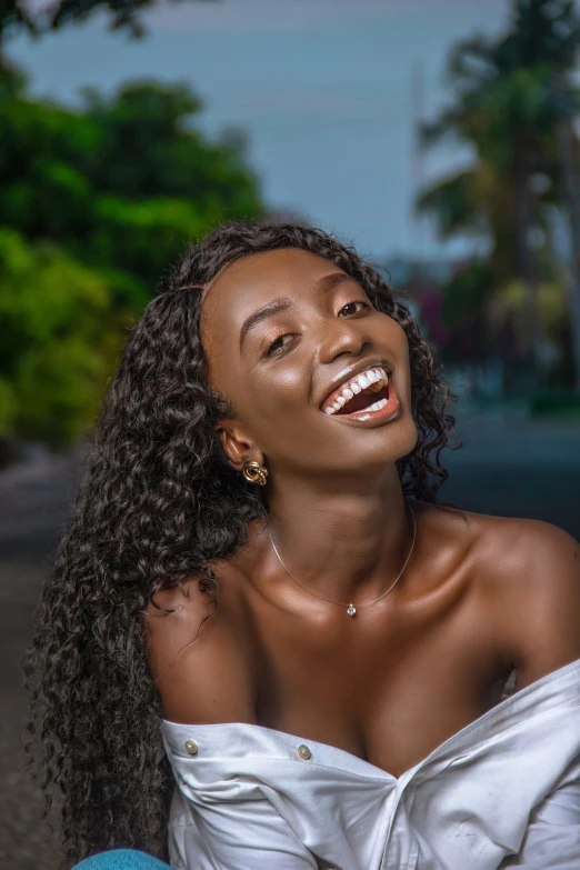 an african woman is laughing while she sits