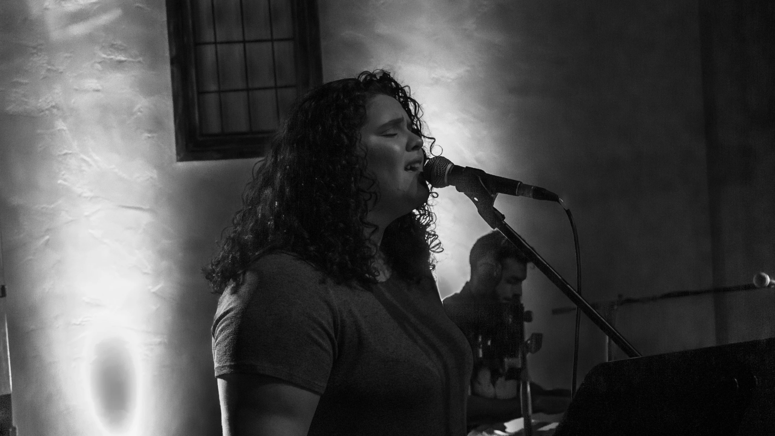 a woman sings in front of an empty bar