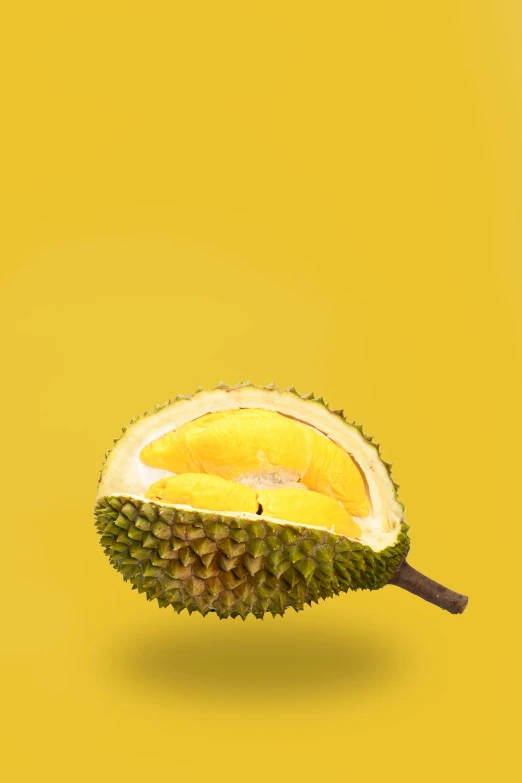 a tropical fruit sliced in half with a yellow background