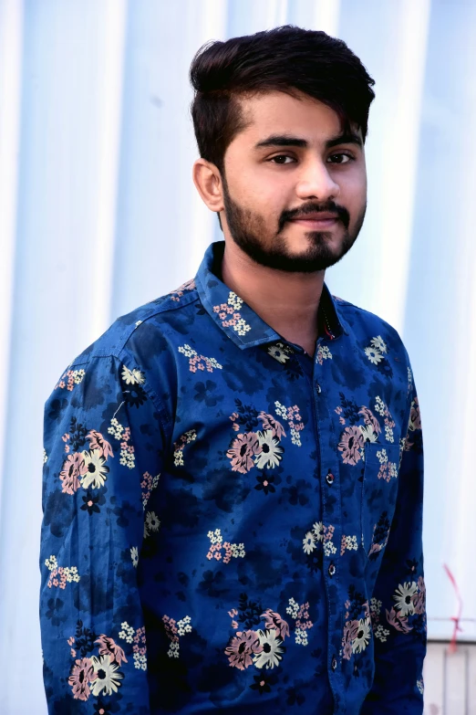 a man that is standing in front of a blue wall