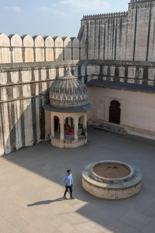 a person standing outside a building with large pillars and columns