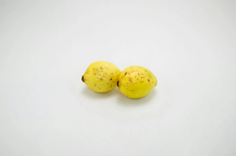 two fruits lying side by side on a white surface