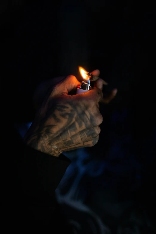 a hand holding a lit candle in the dark