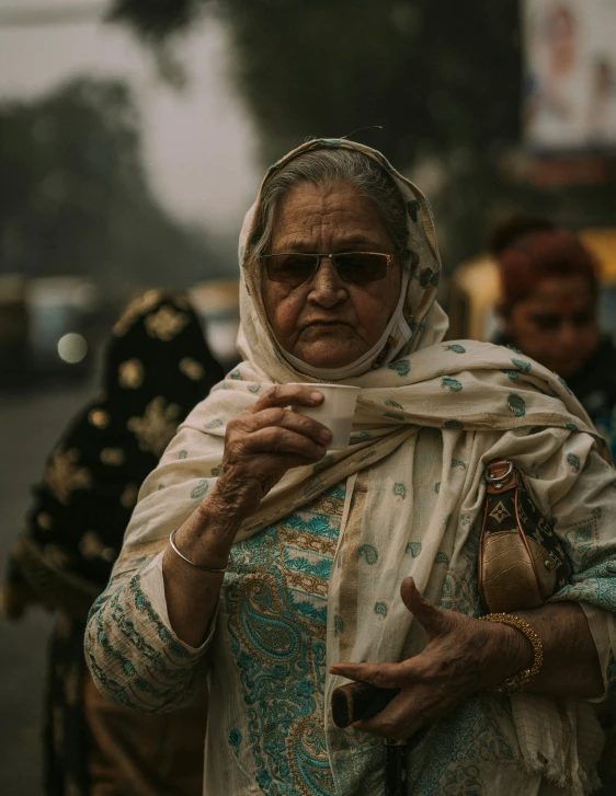 a woman in a scarf with a cup in her hand