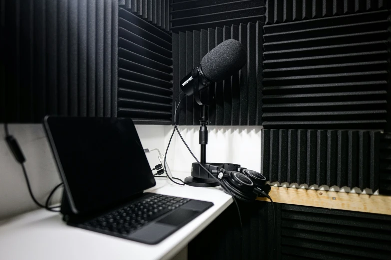 a laptop on a desk with a microphone over it