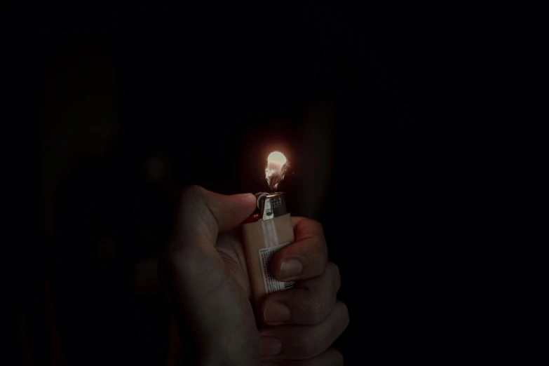 someone holding a lighter in their hand and the light on it is lit