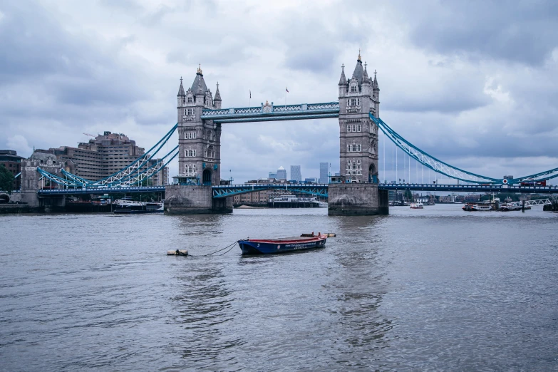 a small boat in the water near a bridge