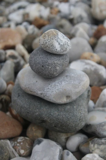 two stacked rocks near one another on a gravel
