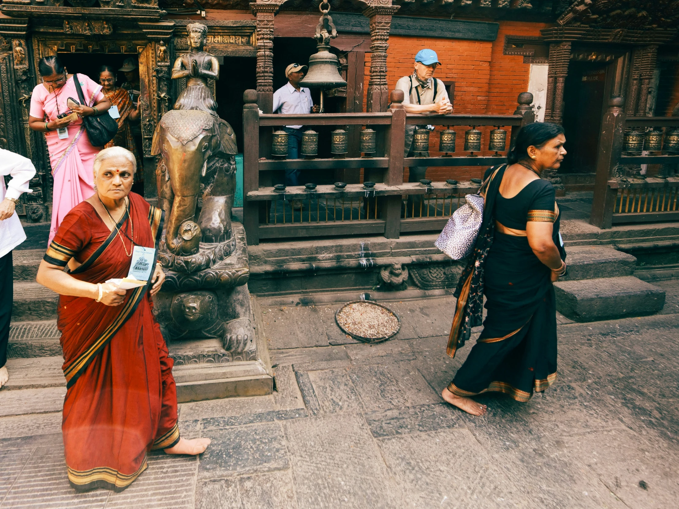 two woman in dress talking to each other while other look on