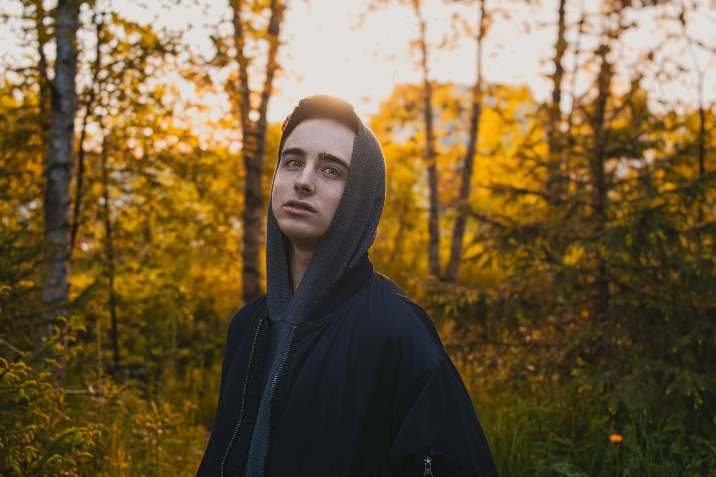 a man standing in the forest looking at the camera