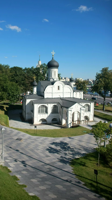 an ornately designed building surrounded by trees in the day time