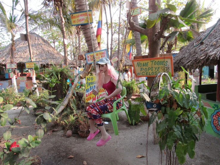 a woman wearing a straw hat sits in front of a forest