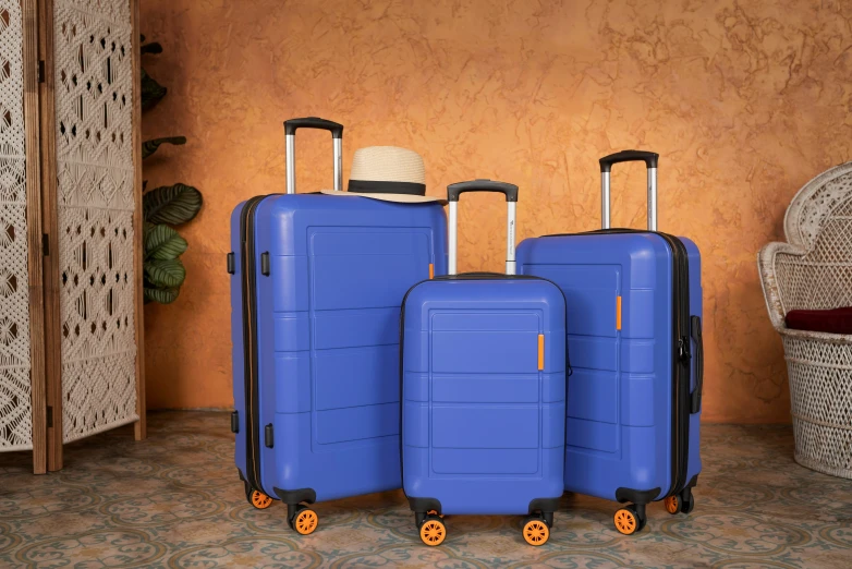 three suitcases are on wheels near a wall