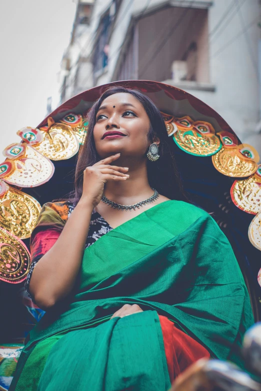 a woman sitting in a small, brightly colored umbrella