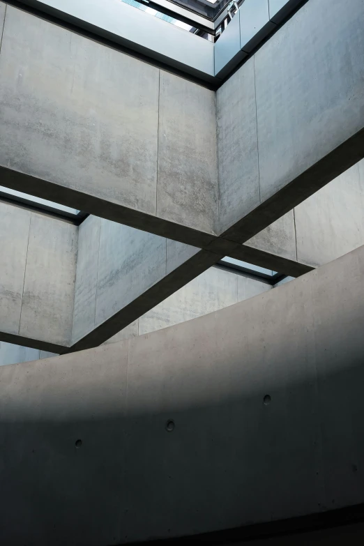 a large atrium space with a skylight and grey concrete walls