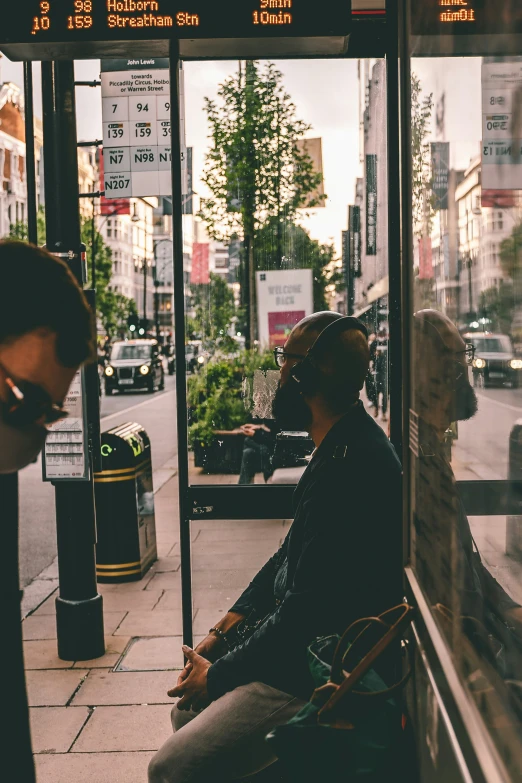 there are people sitting at the bus stop