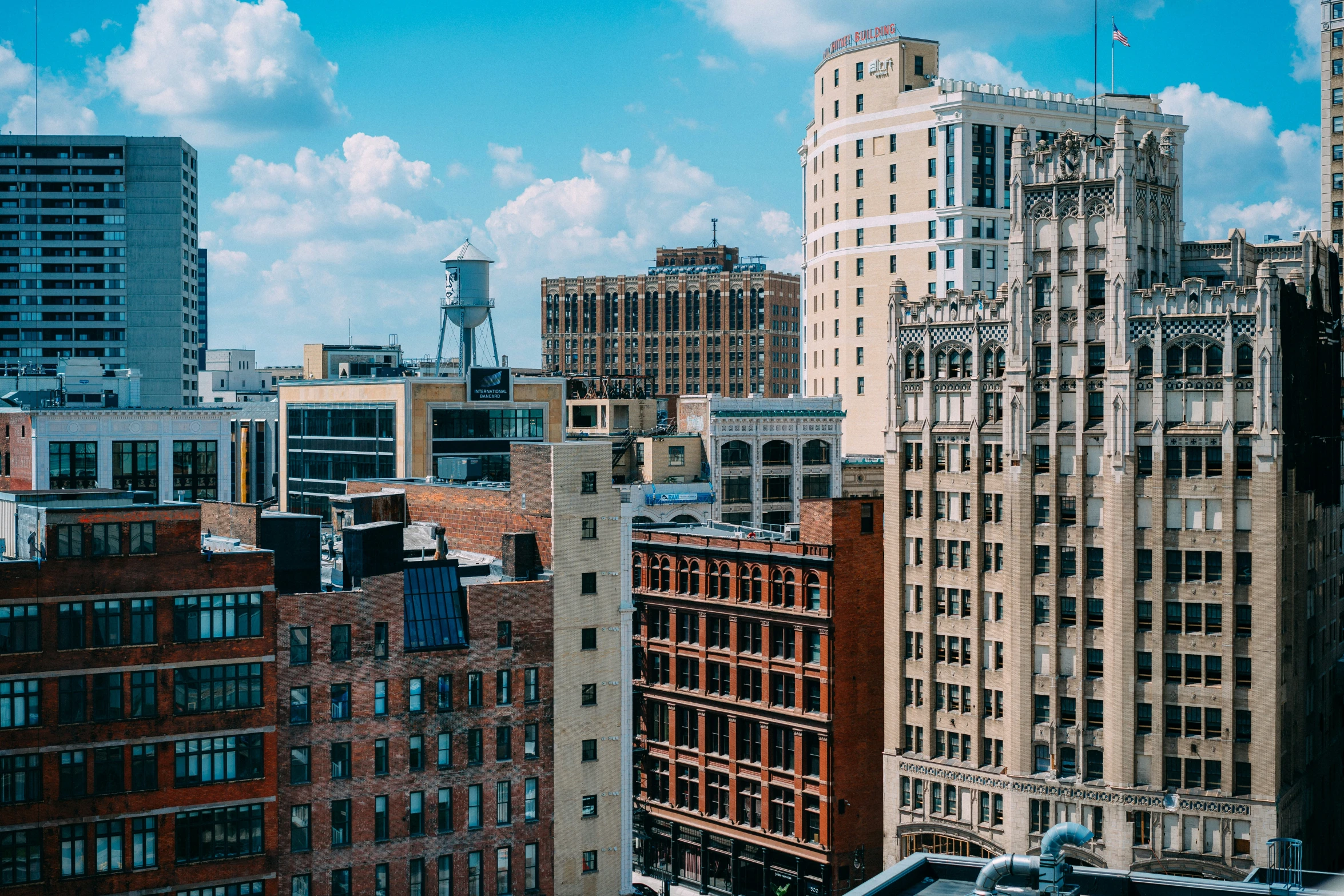 the view of buildings from a rooftop with a blue sky