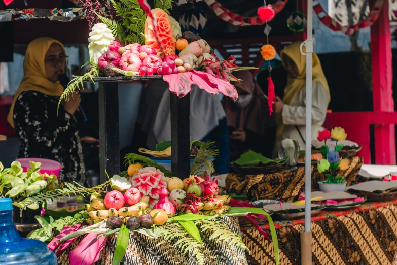 a market with flowers and other things being sold