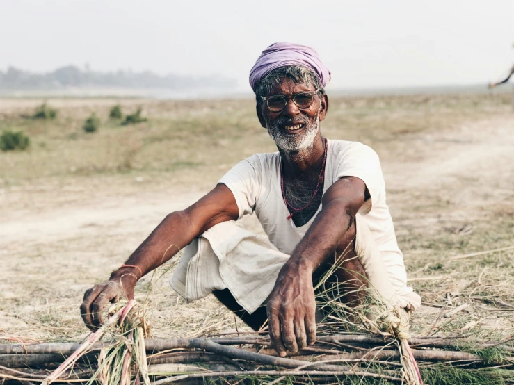 a man kneeling in the grass on a field