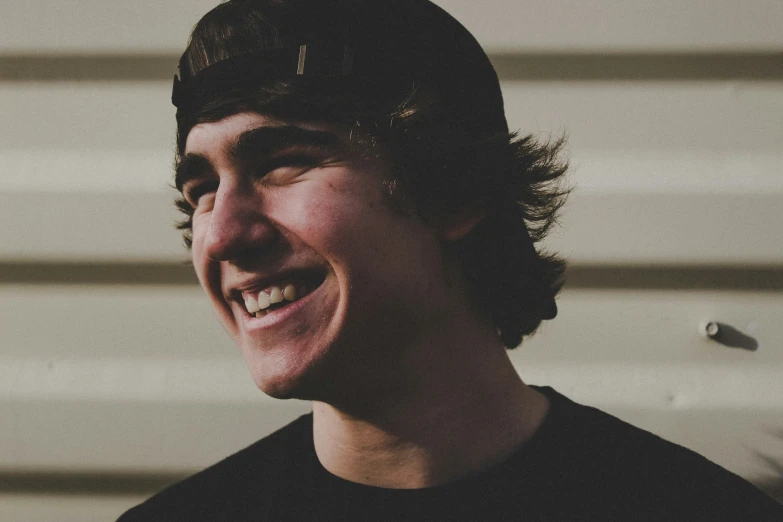 a close - up s of a smiling boy wearing a black shirt