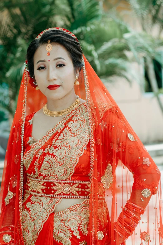 an asian bride posing in a red outfit