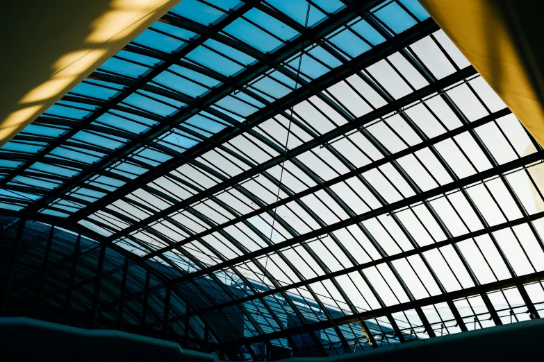 an angled roof structure with blue windows inside of it