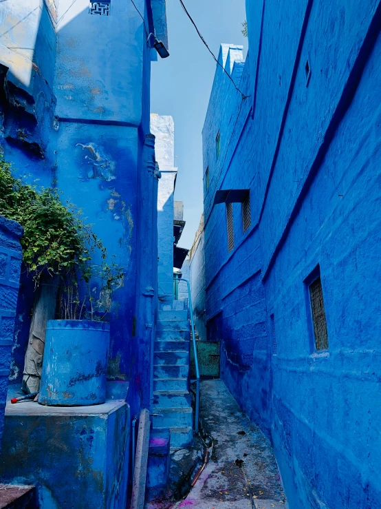 blue buildings in the middle of an alley with stairs