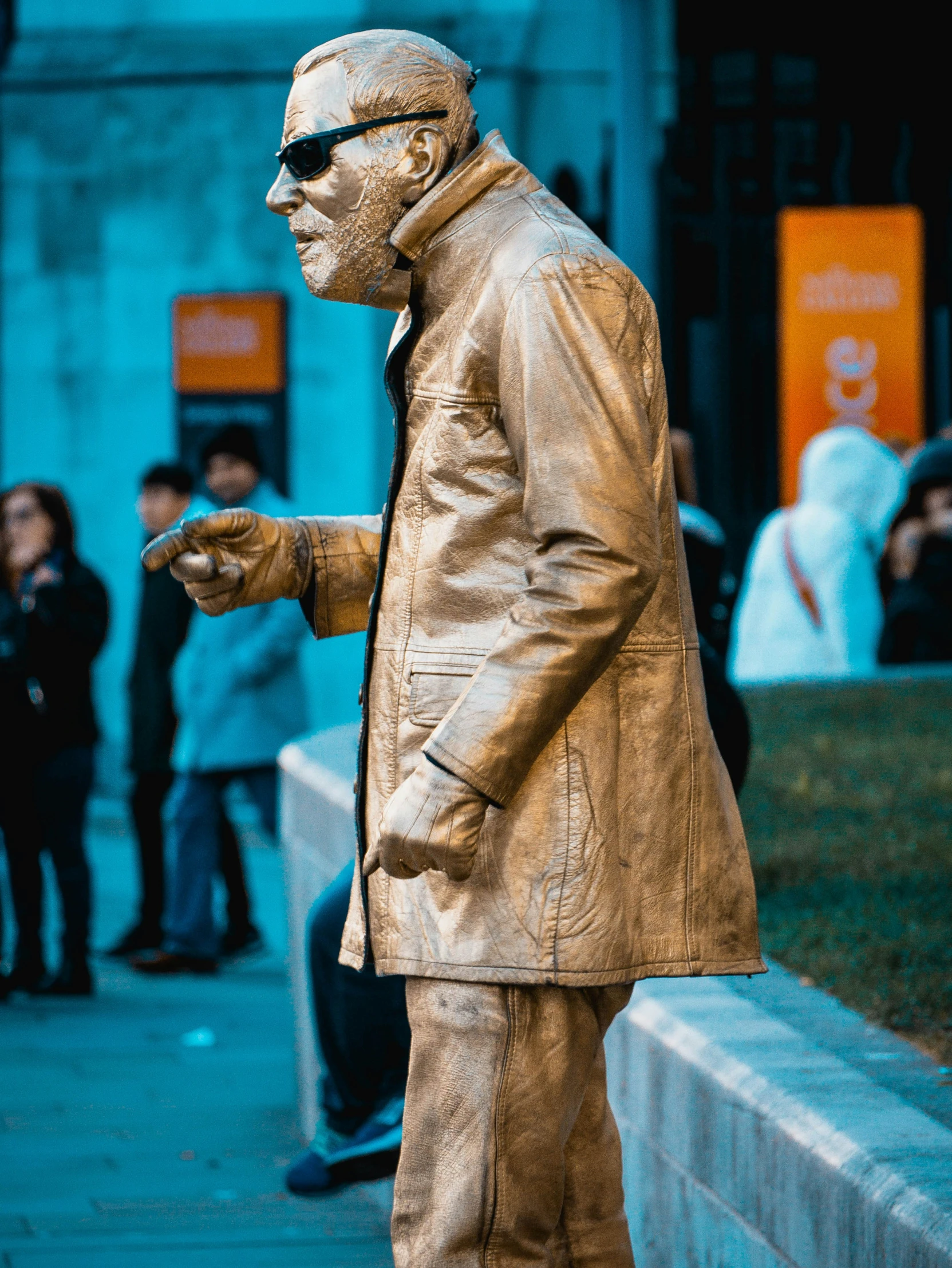 a bronze statue of a man that is standing on the side walk