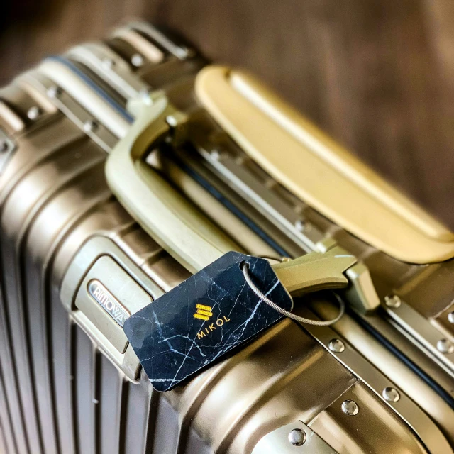 luggage tag sitting on a suitcase with other baggage