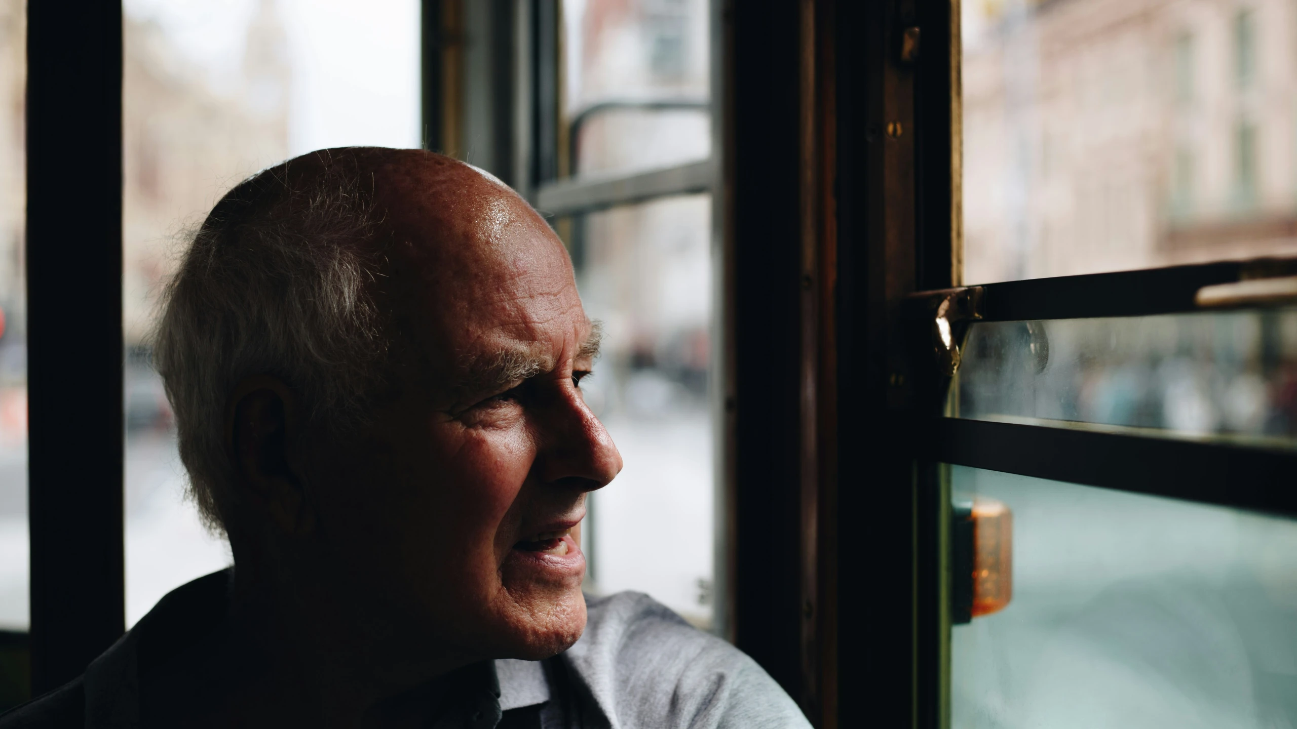 a older man is seen through a glass window