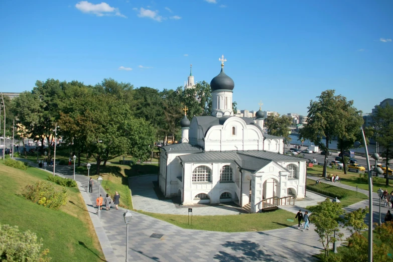 a white building with a circular shaped tower next to trees